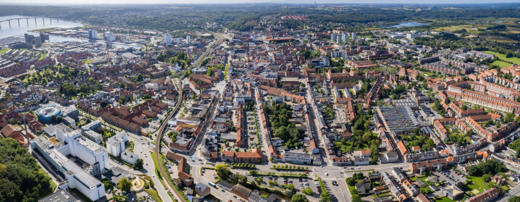 An aerial view of Vejle showing the city skyline and Vejle Fjord.