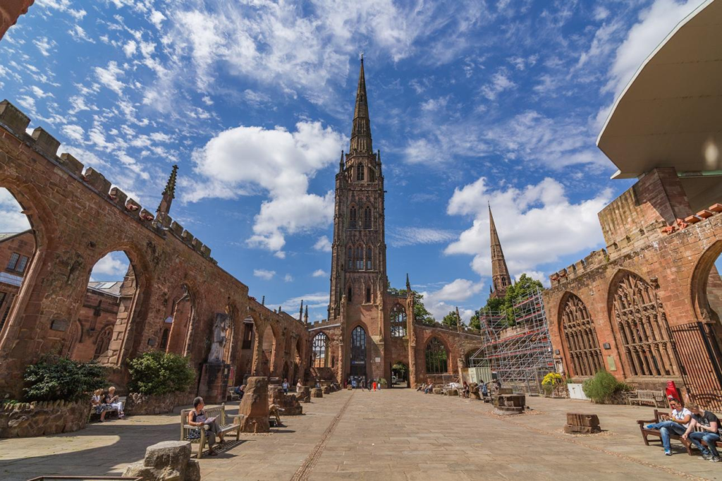 Tourists visiting Coventry Cathedral with modern architecture and historic surroundings.