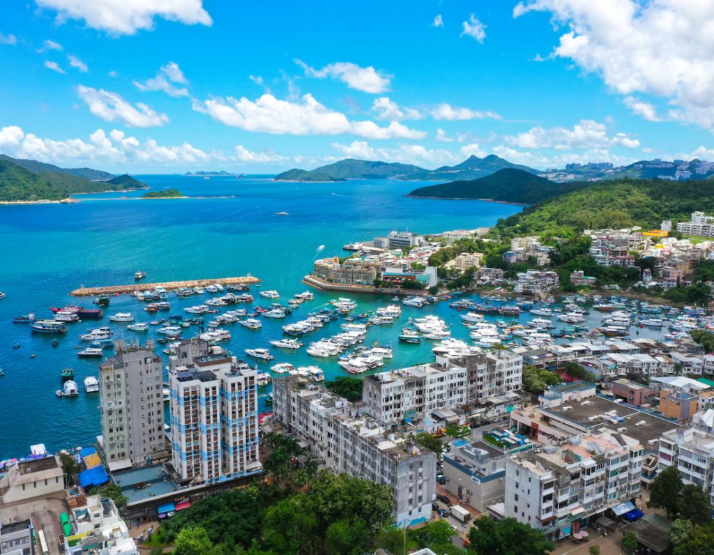 Scenic Sai Kung waterfront with fishing boats, seafood restaurants, and promenade in Hong Kong.