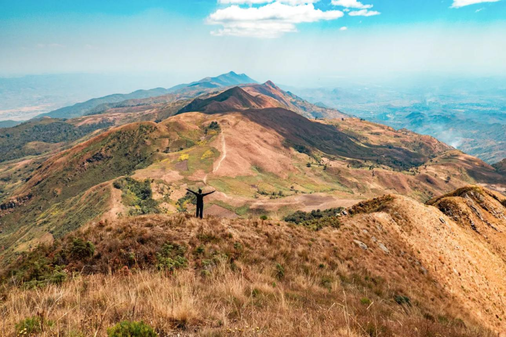 Visitors hiking near Loleza Peak in Mbeya, Tanzania, with mountain views and highland landscapes.