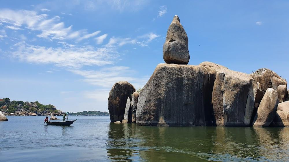 Visitors viewing Bismarck Rock along the shore of Lake Victoria in Mwanza, Tanzania, with scenic waters and city backdrop.