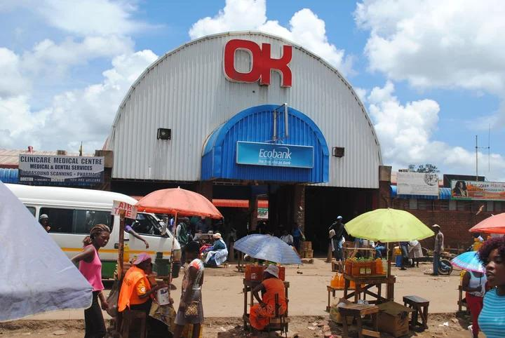 Visitors walking through streets in Chitungwiza with local shops, markets, and pedestrian activity.