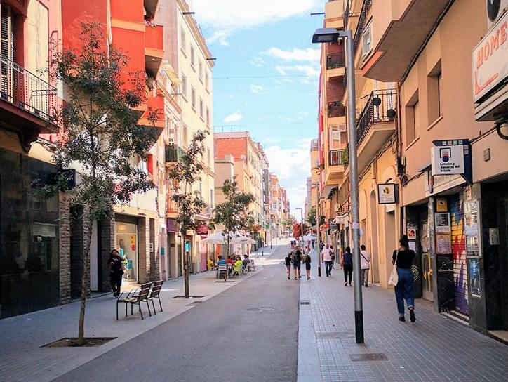 Visitors walking through streets in L’Hospitalet de Llobregat with shops, cafés, and pedestrian activity.