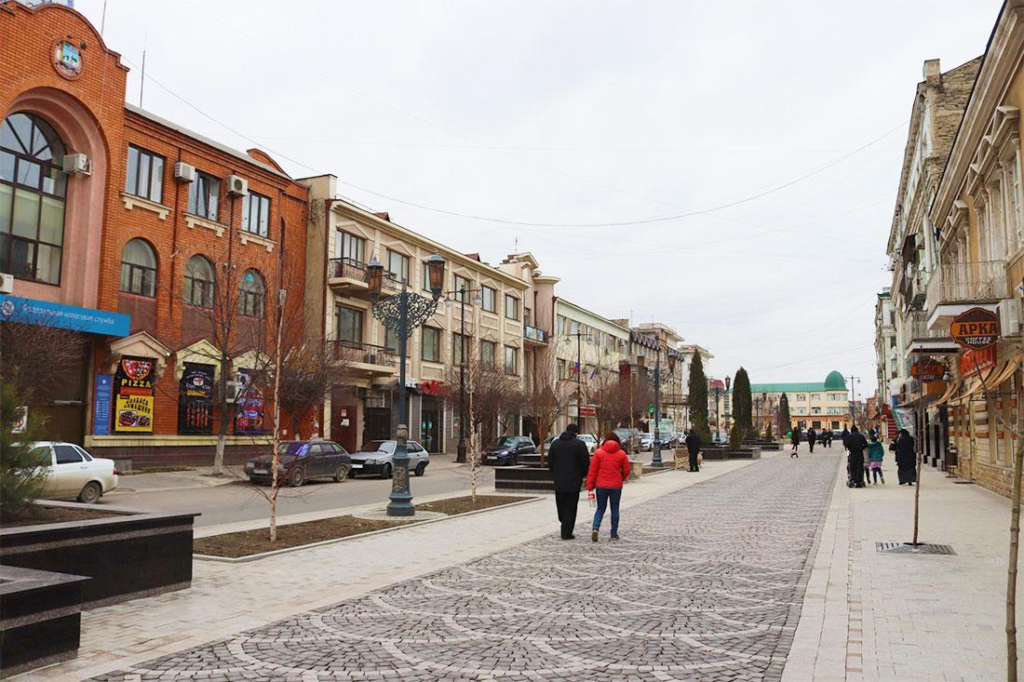 Visitors walking through streets in Makhachkala with local shops, cafés, and pedestrian activity